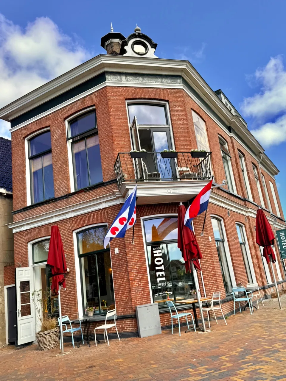 Gevel van Boutique Hotel Joure met Friese vlag en terras