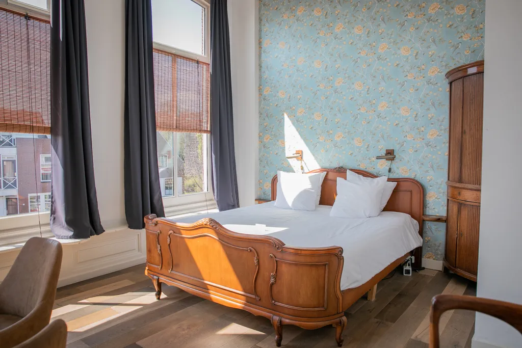 Sfeervolle hotelkamer met klassiek houten bed in Boutique Hotel Joure